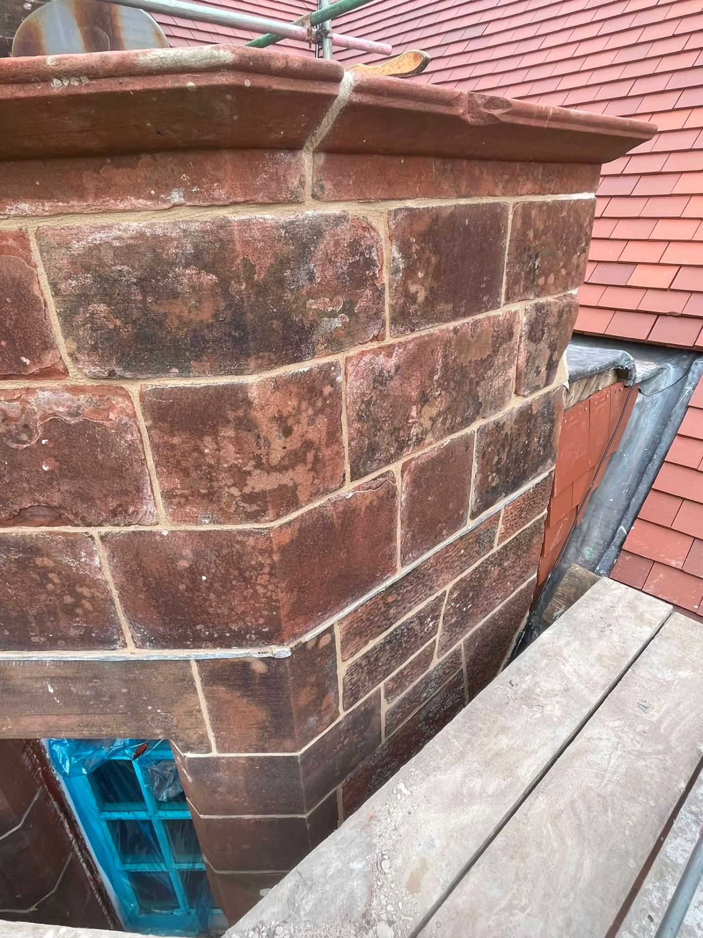Lime pointing in progress on a red sandstone chimney head